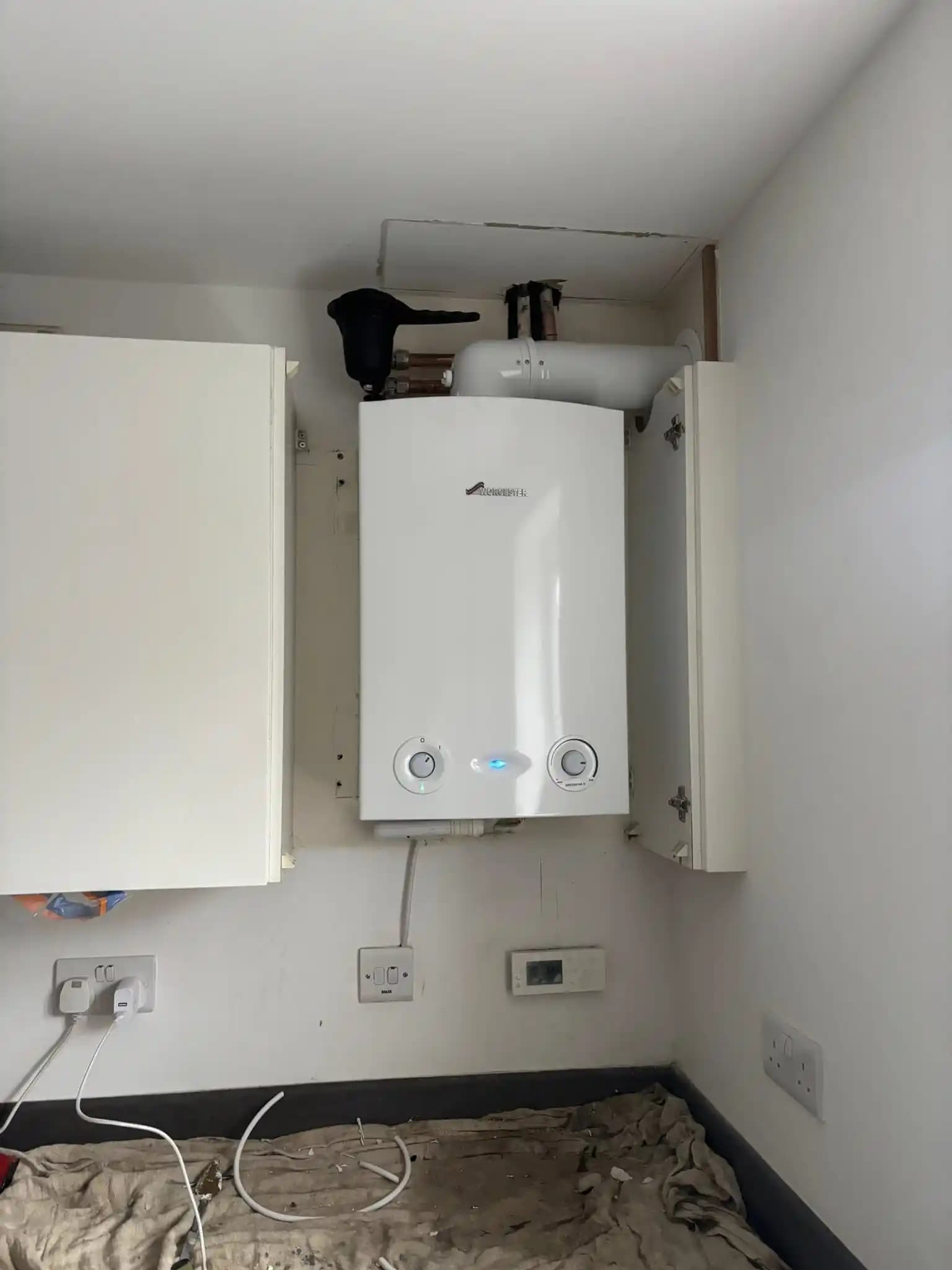 Worcester boiler installed inside a kitchen wall cabinet.